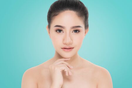 Beautiful Young Woman with clean fresh skin, Proposing a product. Gestures for advertisement on blue backgroundの写真素材
