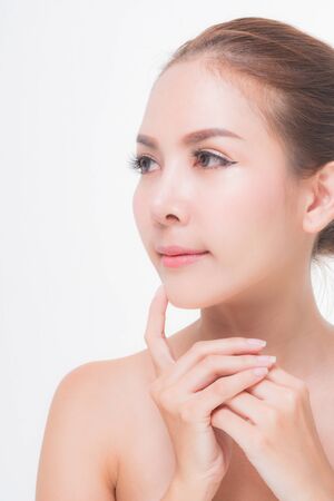 Beautiful young woman with clean fresh skin, Hair sleek, Proposing a product. Gestures for advertisement on pink background, Front view, with copy space.の写真素材