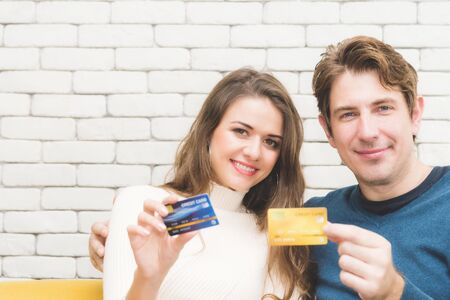 Couple in love posing together while showing credit cards.の写真素材