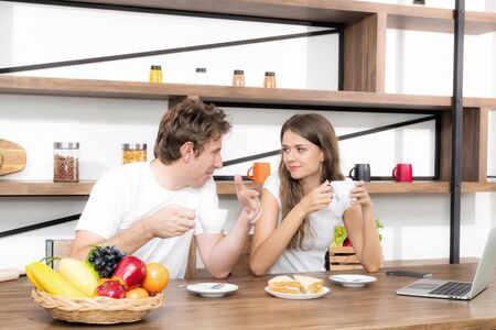 appy couple eating coffee and breakfast early in the morning together at home. and having a good time.の写真素材