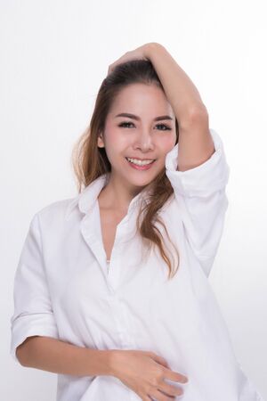 Asian woman portrait with perfect skin and wearing a white shirt in profile isolated on gray background.の写真素材