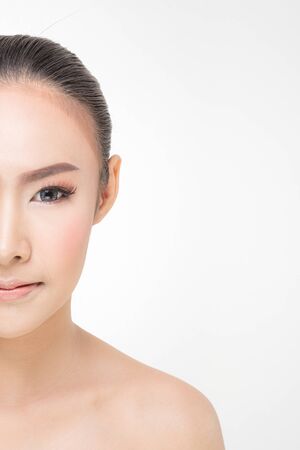 Beautiful young woman with clean fresh skin, Hair sleek, Proposing a product. Gestures for advertisement on pink background, Front view, with copy space.の写真素材