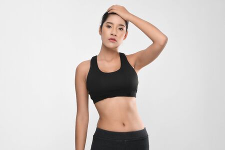 Shapely woman long hair wearing black fitness clothes in a series of exercises isolated on white background.の写真素材