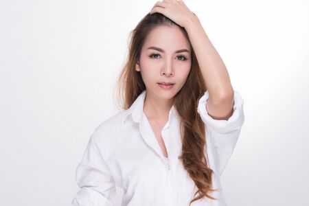 Asian woman portrait with perfect skin and wearing a white shirt in profile isolated on gray background.の写真素材