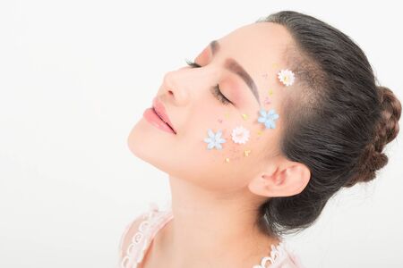 Fashion beauty makeup with flowers on face beautiful woman.の写真素材