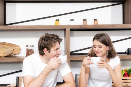 appy couple eating coffee and breakfast early in the morning together at home. and having a good time.の写真素材