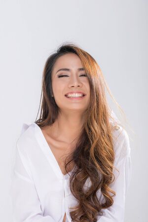 Portrait pretty smiling woman long brown hair posing wearing white shirt shooting in studio shot isolated on a white background.の写真素材
