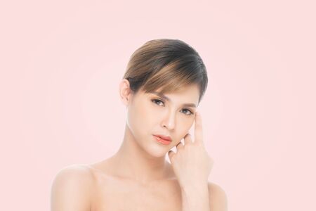 Beauty young woman with clean fresh skin, Proposing a product. Gestures for advertisement isolated on pink background, at copy space.の写真素材