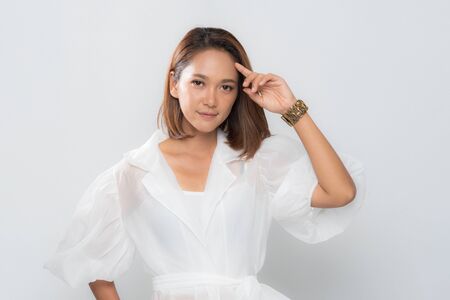 Beautiful asian woman (ages 20-30 years)  happy face, smiling face, both hands catching cheek on white background.の写真素材