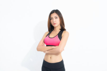 Sporty girl of fitness model wearing pink exercise clothing isolated on white background. Sport and healthy lifestyle.の写真素材
