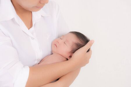 Portrait of woman and little baby, Newborn resting in mother's arm with studio shot isolated on white background.の写真素材