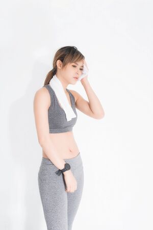 Sporty girl with towel on her shoulders. Photo of fitness model isolated on white background. Sport and healthy lifestyle.の写真素材