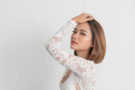 Beautiful portrait asian woman brown short bob wearing a white lace bodysuit on isolated white background. In close-up viewの写真素材
