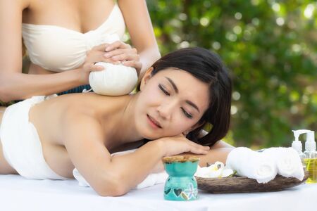 Beautiful young asian woman enjoying massage at outdoors in spa salon, day time.の写真素材