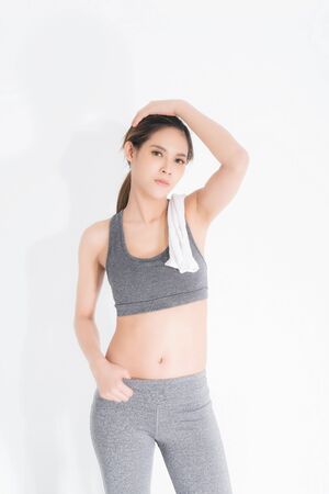 Sporty girl with towel on her shoulders. Photo of fitness model isolated on white background. Sport and healthy lifestyle.の写真素材