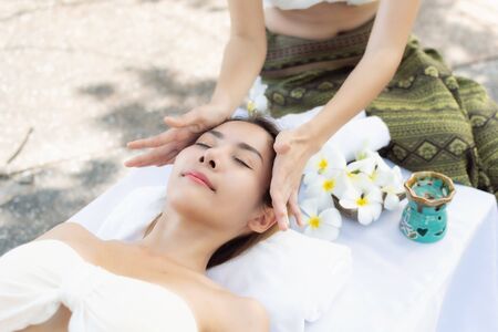 Beautiful young asian woman enjoying massage at outdoors in spa salon, day time.の写真素材