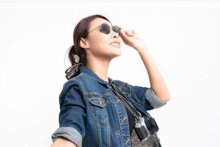 Portrait of happy asian woman in a denim jacket wearing sunglasses holding hand of her boyfriend at studio shot concept isolated on white background. Couple enjoying travel.の写真素材