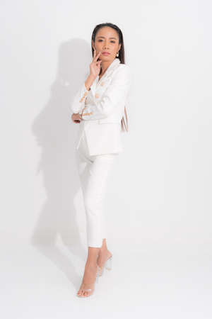 Fashion style catalog clothing for business woman black long hair natural make up wear white suit costume perfect body shape suit at studio shoot on white background and shadow.の写真素材