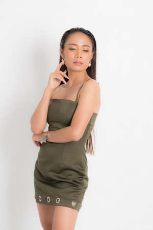 Fashion style catalog casual clothing for party sexy beautiful woman black long hair natural make up wear green dress costume perfect body shape suit at studio shoot on white background and shadow.の写真素材