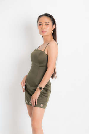 Fashion style catalog casual clothing for party sexy beautiful woman black long hair natural make up wear green dress costume perfect body shape suit at studio shoot on white background and shadow.の写真素材