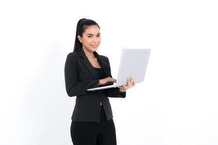 Portrait business woman holding laptop wearing a black suit at studio shot isolated on white background. Pretty female model. Confident professional office worker.の写真素材