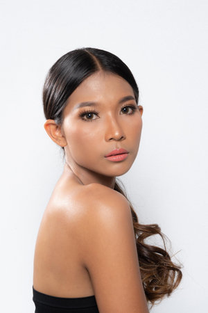 Beauty young dark skinned woman with perfect skin and Makeup. Bridal makeup delicate Pink tones, Wet make-up, shine. sexy lips. vivid pink makeup on white background. Close up shot.の写真素材
