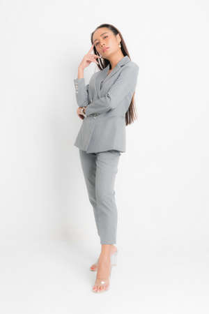 Fashion style catalog clothing for business woman black long hair natural make up wear gray suit costume perfect body shape suit at studio shoot on white background and shadow.の写真素材