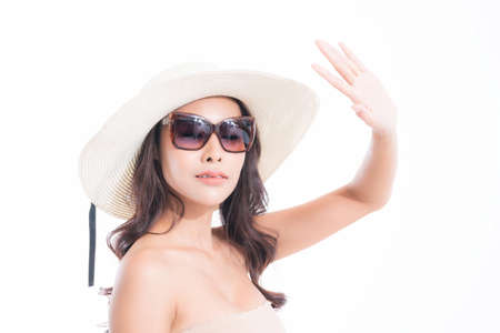 Close-up, Beautiful woman portrait face in sun hat and sunglasses enjoying with sun at studio shot isolated on white background. Sun protection concept.の写真素材