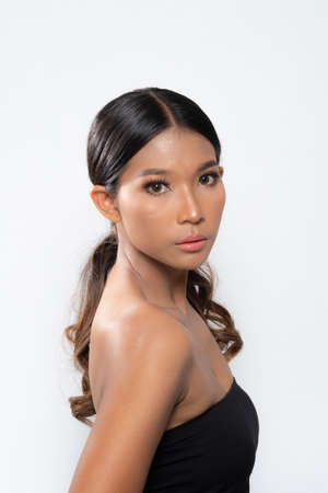 Beauty young dark skinned woman with perfect skin and Makeup. Bridal makeup delicate Pink tones, Wet make-up, shine. sexy lips. vivid pink makeup on white background. Close up shot.の写真素材