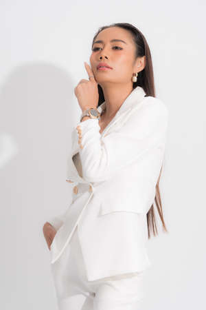 Fashion style catalog clothing for business woman black long hair natural make up wear white suit costume perfect body shape suit at studio shoot on white background and shadow.の写真素材