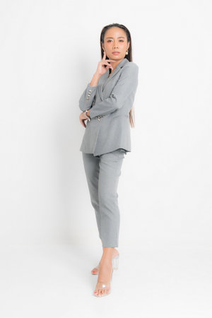 Fashion style catalog clothing for business woman black long hair natural make up wear gray suit costume perfect body shape suit at studio shoot on white background and shadow.の写真素材