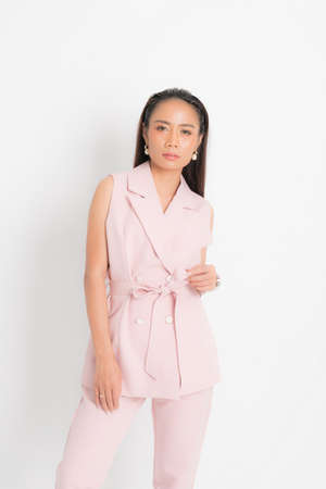Fashion style catalog clothing for business woman black long hair natural make up wear pink suit costume perfect body shape suit at studio shoot on white background and shadow.の写真素材