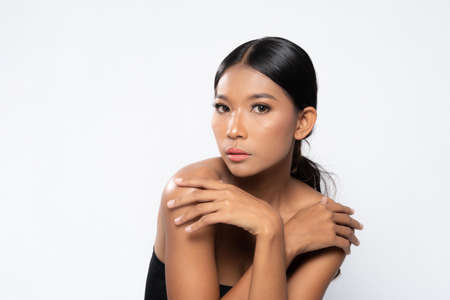 Beauty young dark skinned woman with perfect skin and Makeup. Bridal makeup delicate Pink tones, Wet make-up, shine. sexy lips. vivid pink makeup on white background. Close up shot.の写真素材
