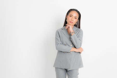 Fashion style catalog clothing for business woman black long hair natural make up wear gray suit costume perfect body shape suit at studio shoot on white background and shadow.の写真素材