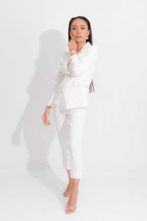 Fashion style catalog clothing for business woman black long hair natural make up wear white suit costume perfect body shape suit at studio shoot on white background and shadow.の写真素材