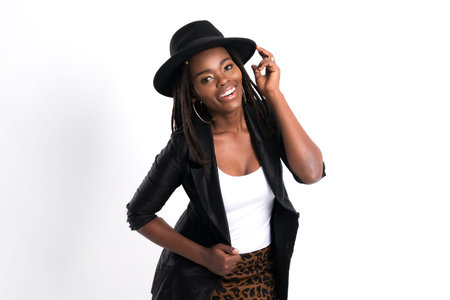 Portrait of a woman with dreadlocks and a fedora hat, expressing pure joy and confidence with a wide...