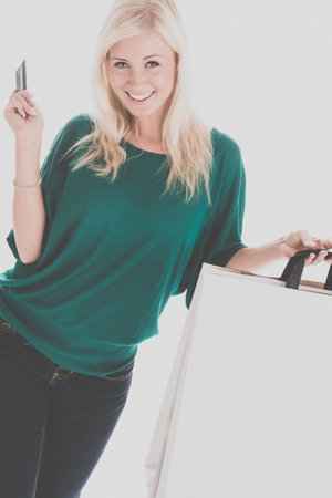 Smiling woman with credit card and shopping bagsの写真素材