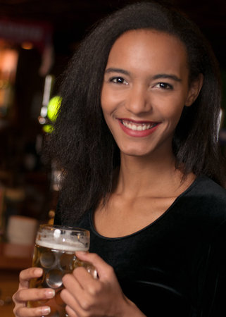 Young african american woman holding beerの写真素材