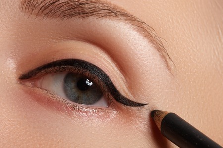 Make-up beauty with brush eye liner on pretty woman faceの写真素材