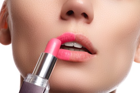 Part of attractive woman's face with fashion red lips makeup. Make-up artist apply pink lipstickの写真素材
