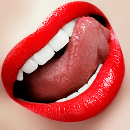 Close-up happy female smile with healthy white teeth. Cosmetology, dentistry. Macro of woman's smiling mouth. Beautiful lip makeup. Sensual Open Mouth with. Lipstick and lip gloss. Fashion make upの写真素材