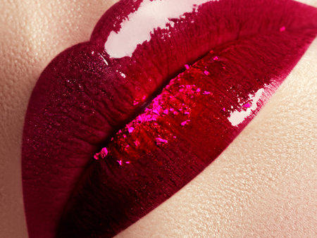 Close-up of beautiful full woman's lips with bright fashion gloss pink makeup. Macro shot with magenta lip makeup. Beautiful red lips with pink pigment. Beauty and fashion conceptの写真素材