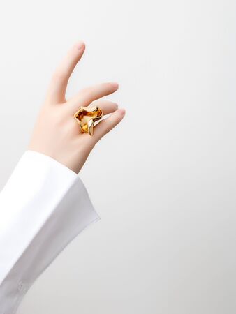 Simple beauty concept - jewelry accessories . Beauty delicate hands with manicure close up . Beautiful female fingers with manicure and fashionable gold ring . Minimalistic fashion photographyの写真素材