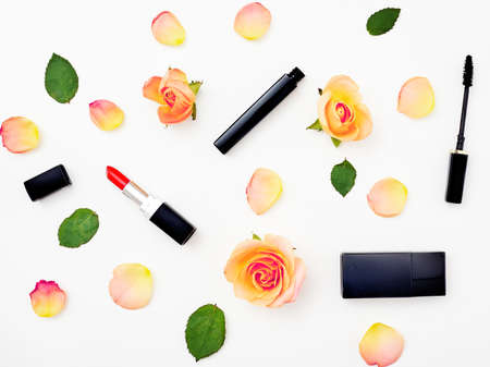 Decorative flat lay composition with cosmetics and flowers. Top view on white backgroundの写真素材