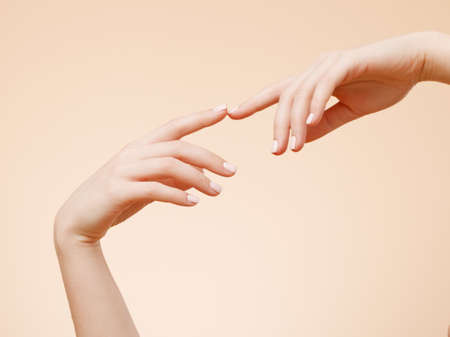 Beauty and spa. Beautiful Female Hands. Manicure concept. Soft skin, skin care concept over beige backgroundの写真素材