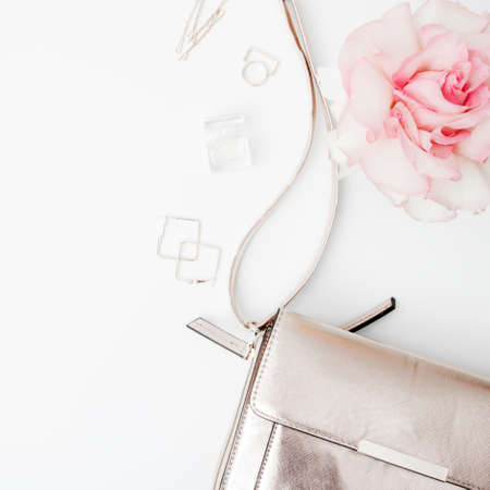 Minimal style. Minimalist Fashion photography. Decorative flat lay composition with cosmetics, womens accessories and flowers. Flat lay, top view on white backgroundの写真素材
