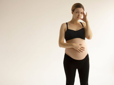 Pregnant woman with a headache and pain. Young pregnant woman with headache and backache copy space....