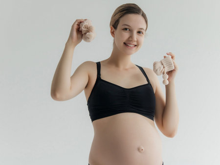 Pregnant woman holding baby cloth for baby newborn isolated on white background.Pregnant woman...