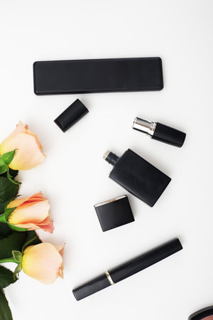 Decorative flat lay composition with cosmetics and flowers. Top view on white backgroundの写真素材