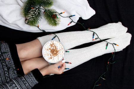 Cup of tasty cocoa drink and marshmallows in hands.Spices and marshmallows for winter drinks on a...